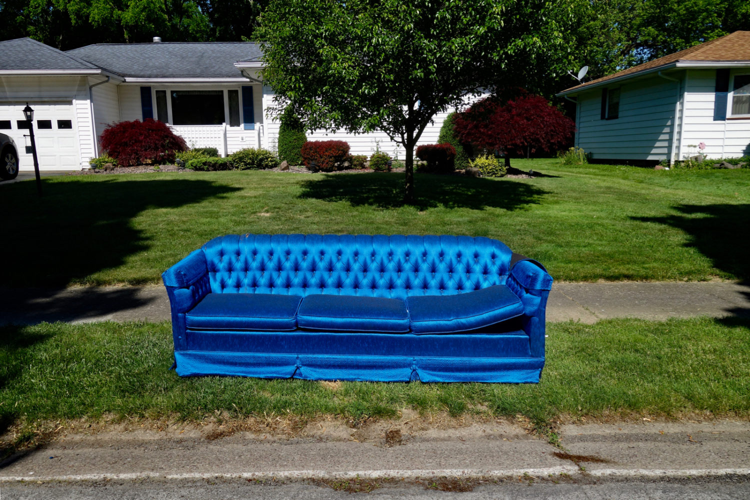 Bright blue couch at curb on side street off Wahl Road, Rochester NY.